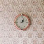 retro oink clock on a vintage style wallpapered wall