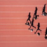 Atheletes on running track in sunshine